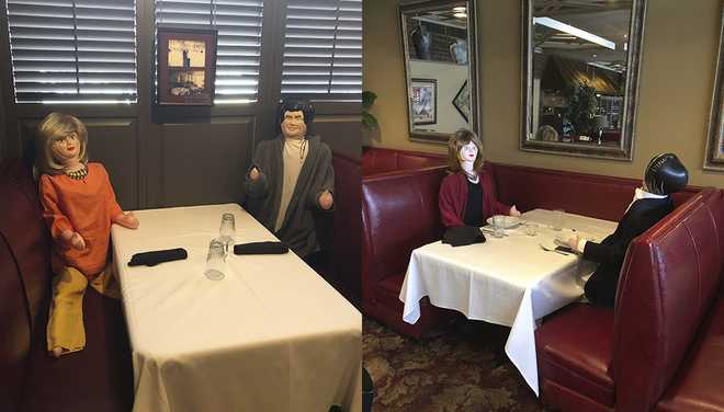 Inflatable dolls seated in restaurant booth